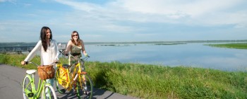 women walking with their bikes, Big Lake in the background