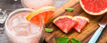 cocktail with grapefruit displayed with cutting board